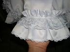 Bottom ruffle is satin stitched along the top, has flat lace along the bottom, and is attached with ruffled white lace with bow design throughout.